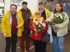 Bestuursleden van N-VA Oostrozebeke kopen een bloemetje en delen chocolaatjes uit op de Mark